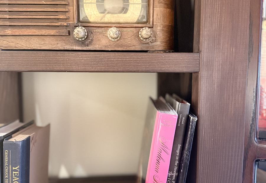 A vintage radio on a shelf of books